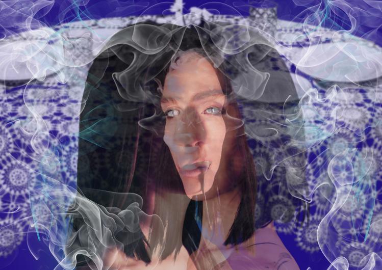 Nahes Porträt vor blau gemustertem Hintergrund; Rauchschwaden umrahmen das Gesicht, eine helle Flüssigkeit läuft aus dem Mundwinkel.