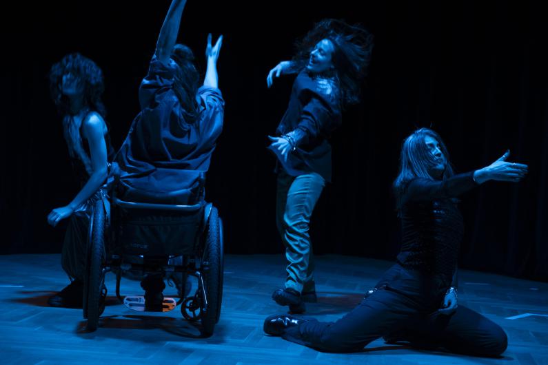 Vier weiße Körper tanzen in der Dunkelheit. Nachtblaue Schimmer auf der Haut, auf Schultern, Unterarmen, Rädern, Beinen. Arme strecken sich aus, Hände greifen, die Finger gespreizt. Wildes Haar wirbelt auf, fällt ins Gesicht. Ein forderndes Schmunzeln, ein genussvolles Lachen, ein konzentrierter Blick.