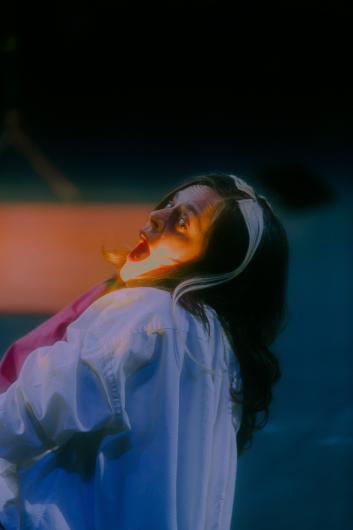 Close-up of a person on stage tilting their head back with an open mouth, captured in a moment of intense emotion.