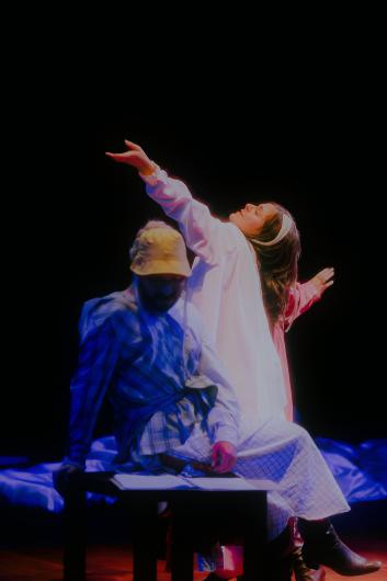 A blurred double exposure shows a person in motion wearing red and white garments against a dark background.